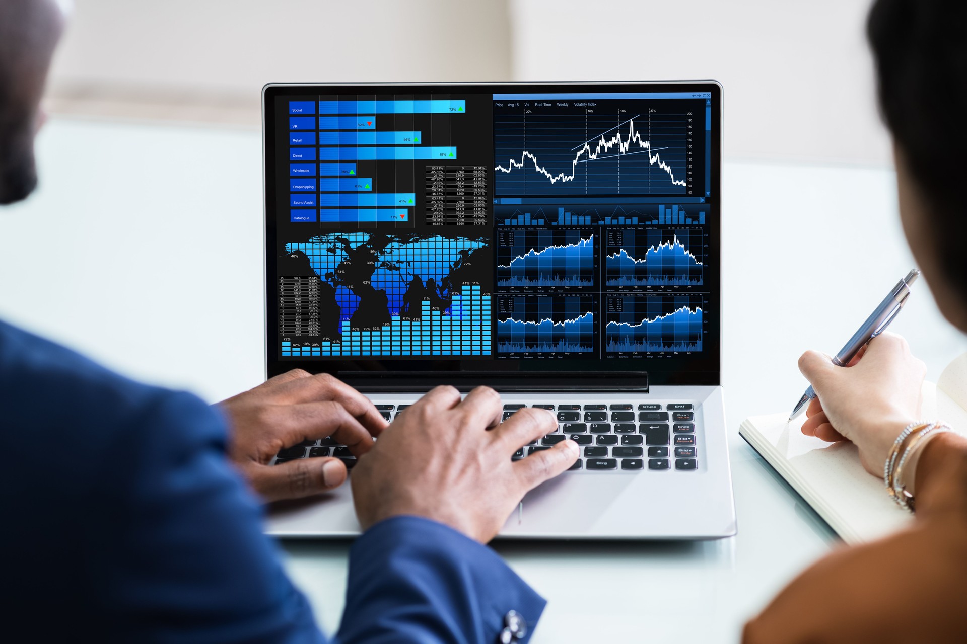People Analyzing Graph On Laptop