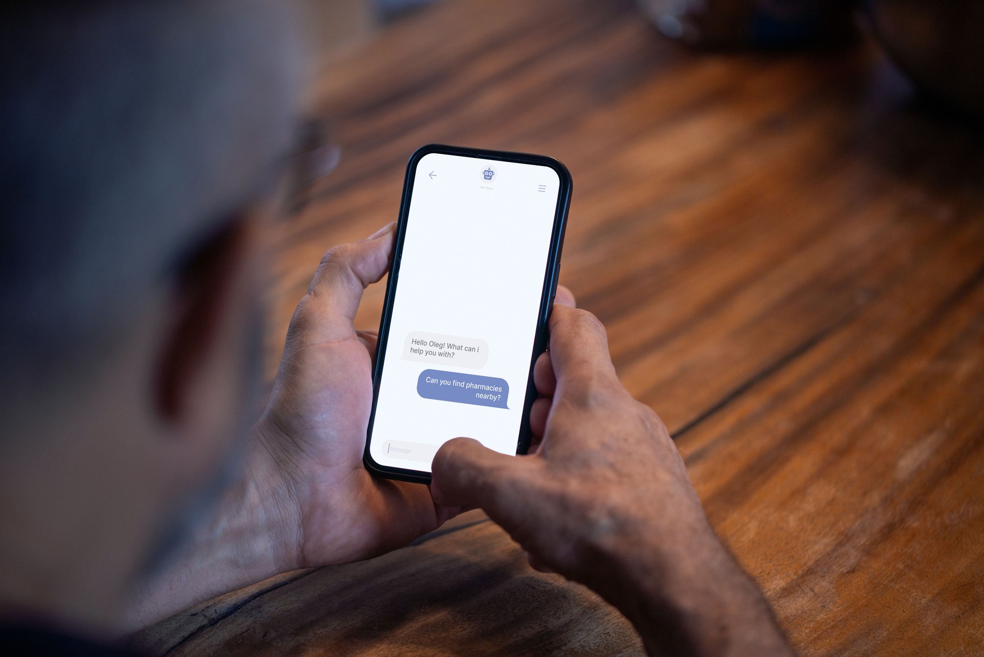 Mature man uses chatbot on smartphone to get information about nearby pharmacies