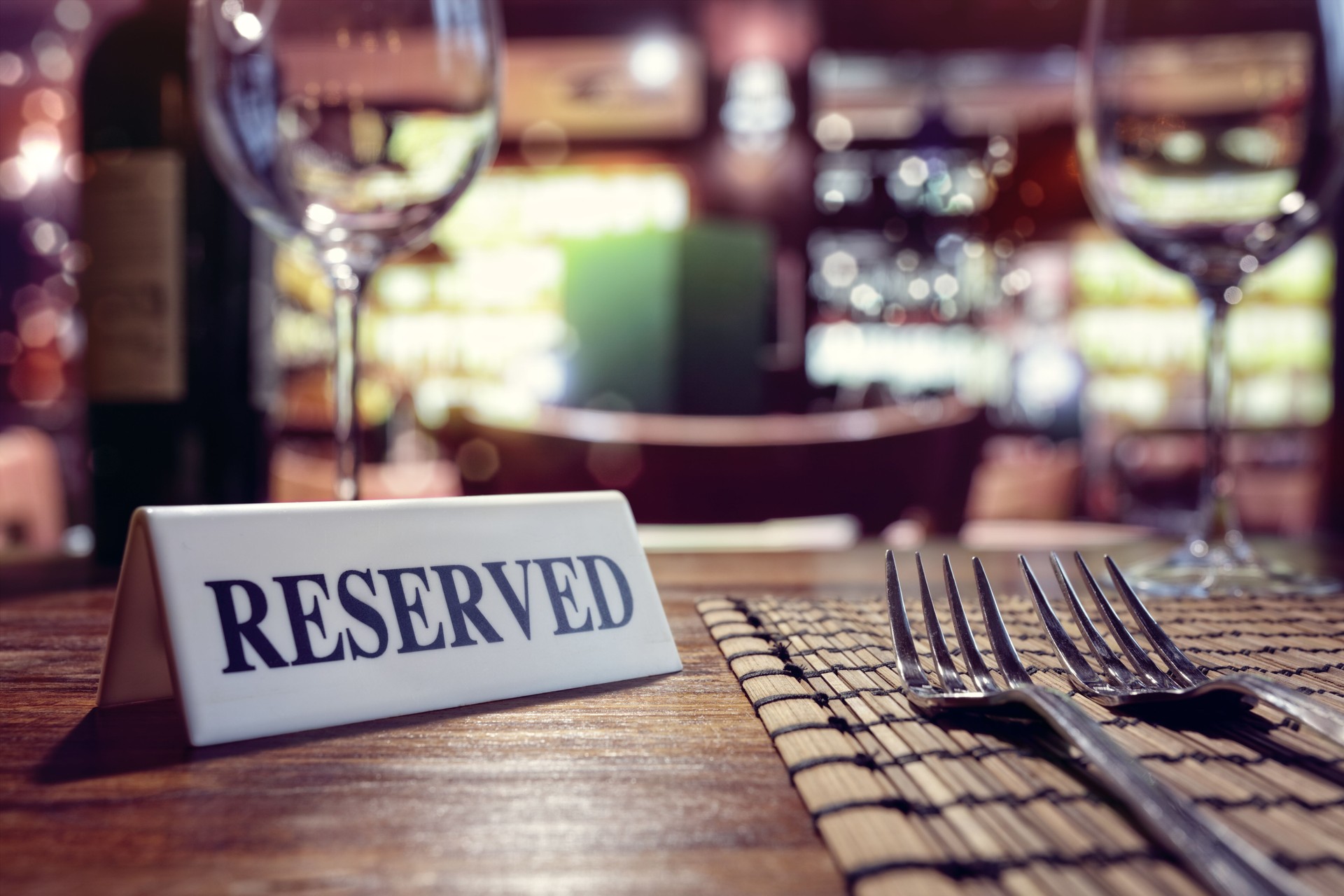 Reserved sign on restaurant table with bar background